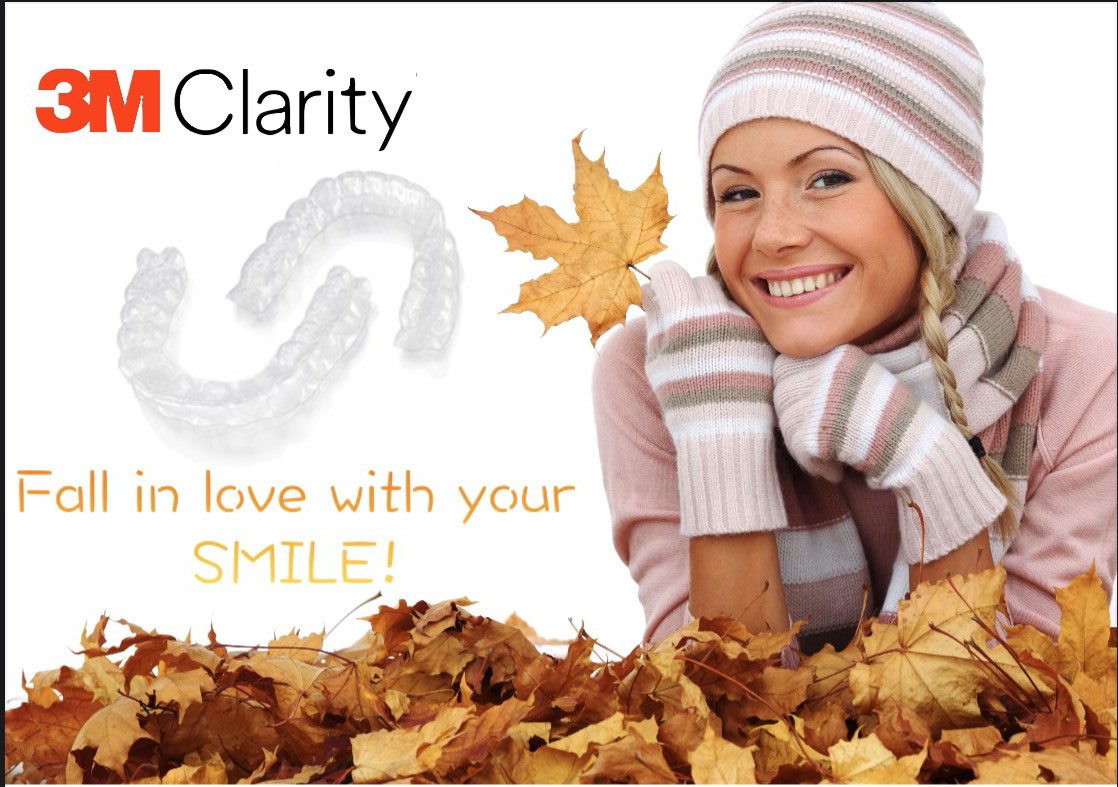 Woman smiling in fall attire with Clarity braces and autumn leaves background.