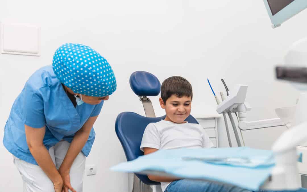 A child smiling while seated in a dental chair during a comfortable pediatric dental visit