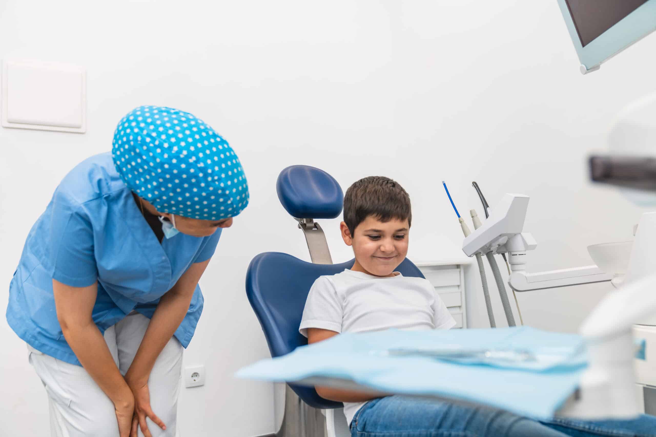 A child smiling while seated in a dental chair during a comfortable pediatric dental visit