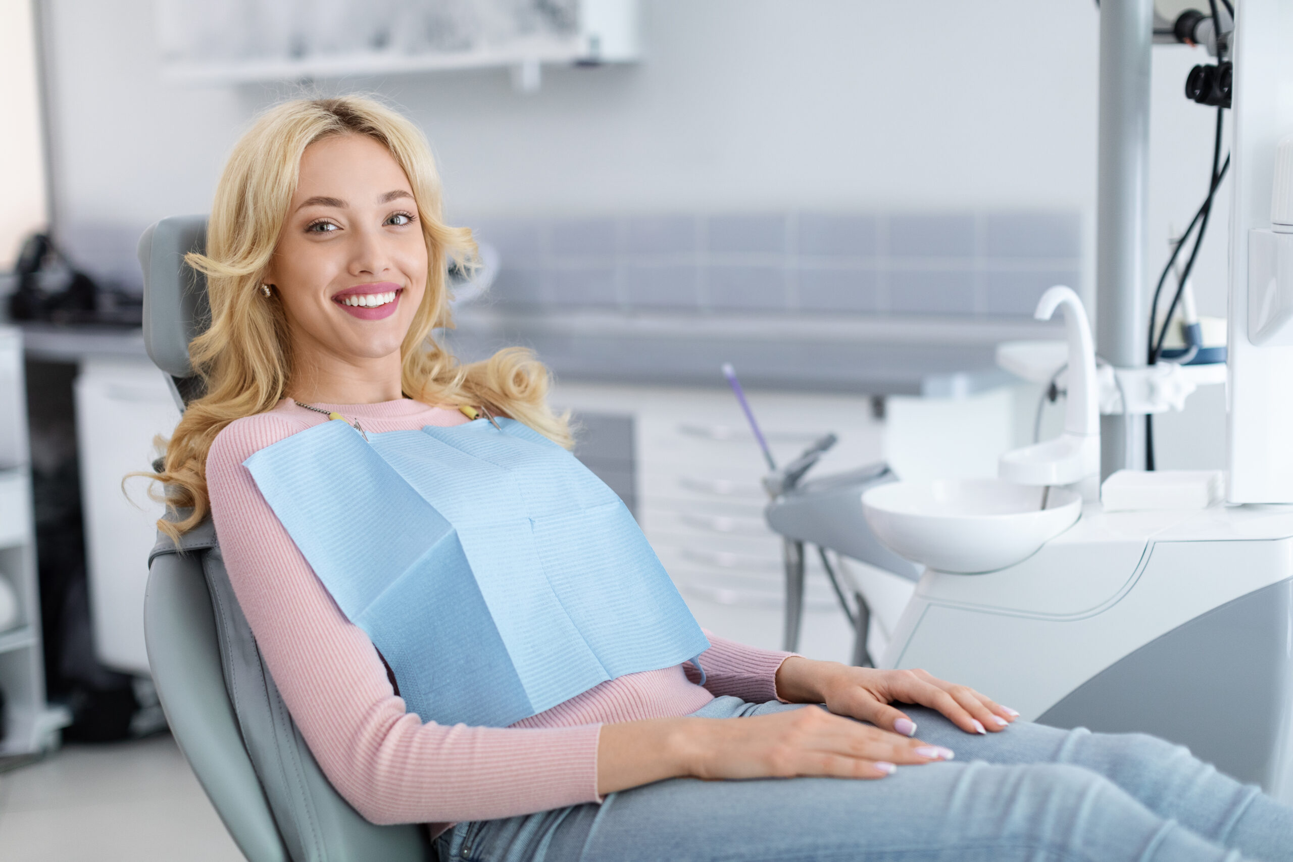 Adult patient smiling comfortably in a dental chair during a cosmetic dentistry visit, reflecting confidence and relaxed care