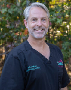 Portrait of Dr. David Moran, DMD, cosmetic dentist at Adult & Pediatric Dental Studio in New Jersey, smiling outdoors in professional attire