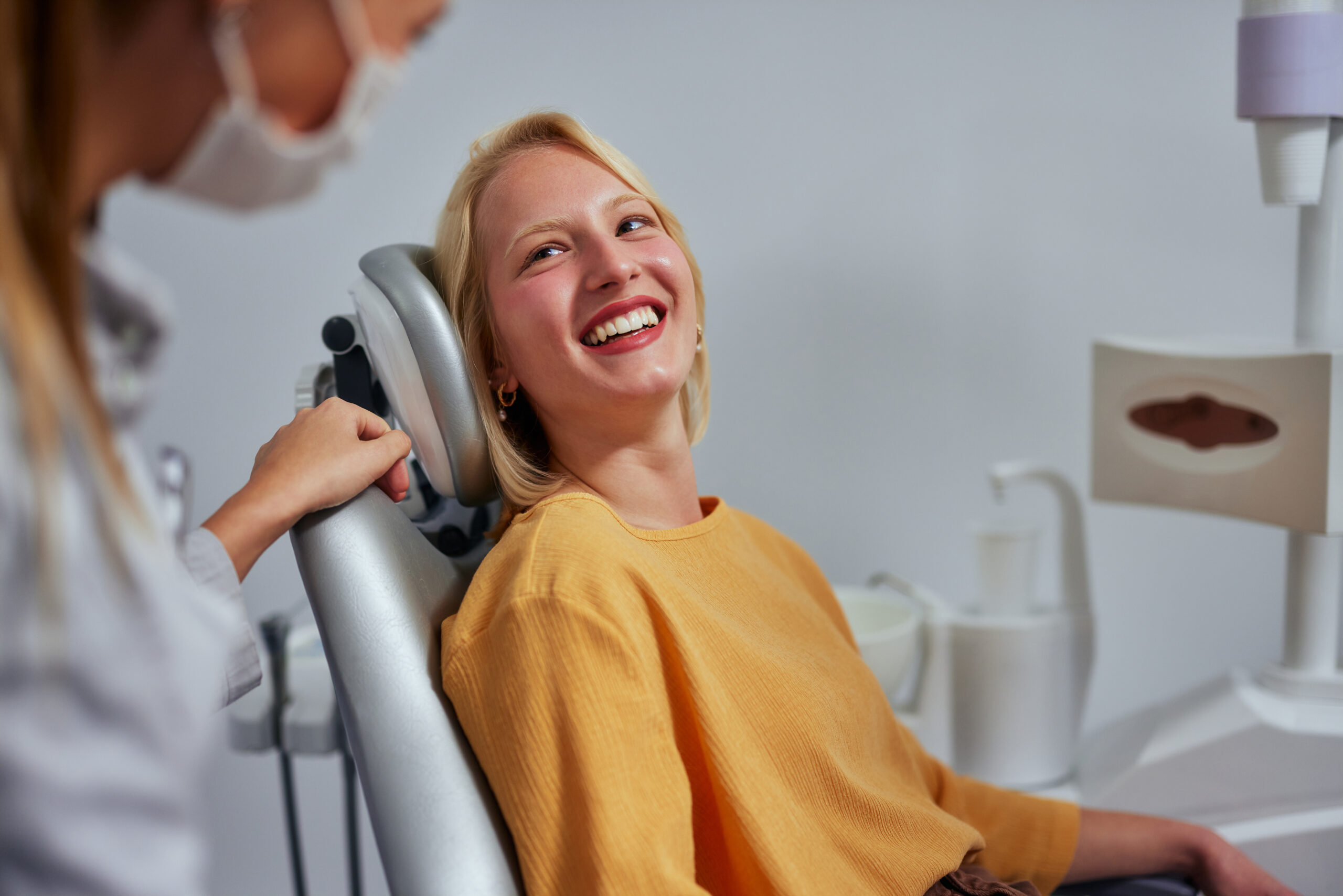 Patient smiling and talking with a dentist during a comfortable dental visit, reflecting a calm and safe care experience