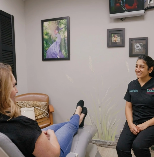 Dentist at Adult & Pediatric Dental Studio consulting with a patient in a safari themed treatment room