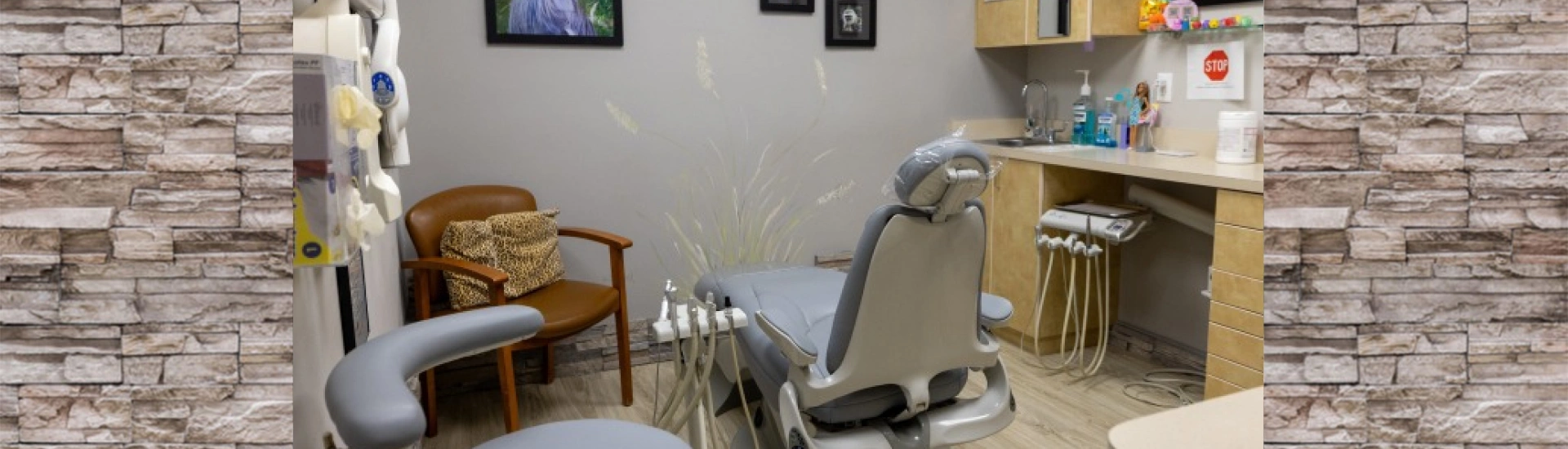 A bright, modern clinical room with an examination chair and stylized wall decorations
