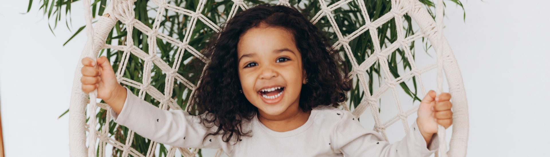 A cheerful young child laughing during an outdoor or indoor playtime session