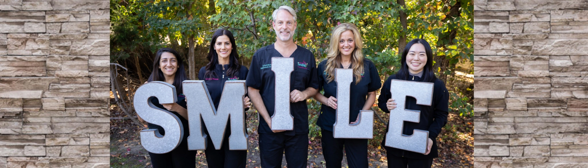 Dental team banner photo with staff members holding "SMILE" letters