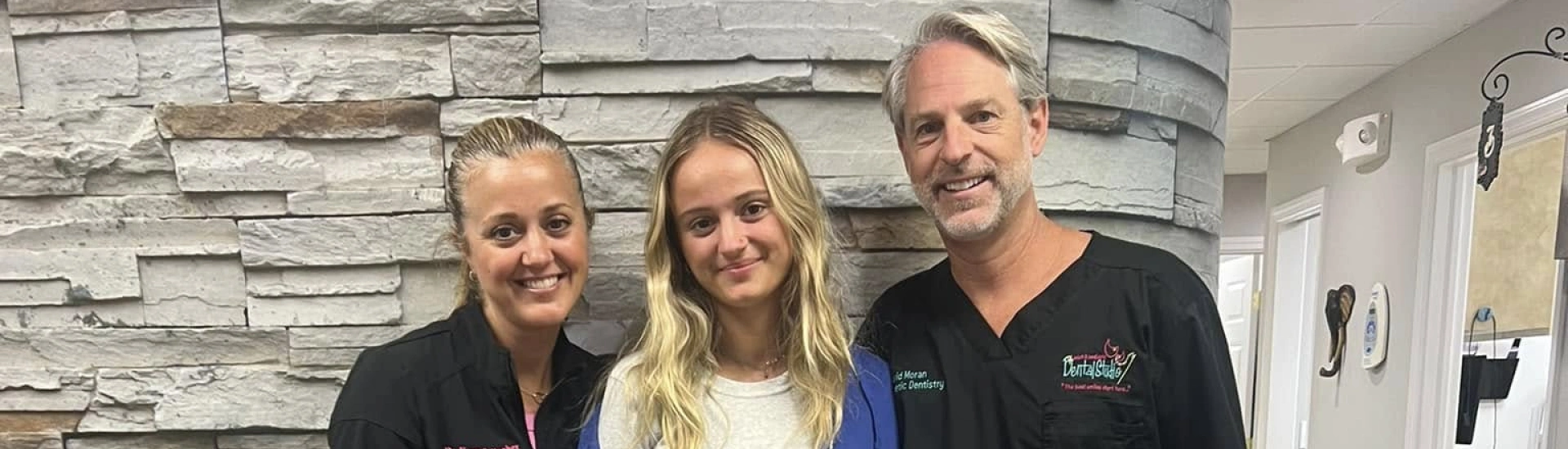 Adult & Pediatric Dental Studio team members posing with a happy orthodontics patient