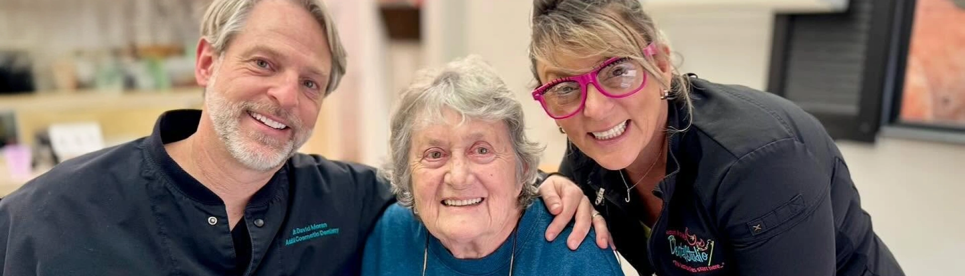 Adult & Pediatric Dental Studio team members posing with a happy senior patient