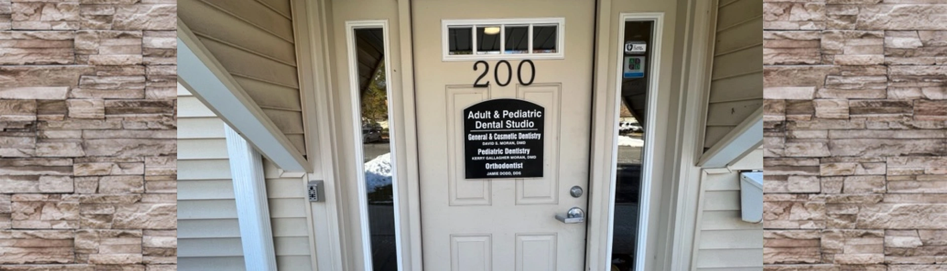 The front entrance door of Adult & Pediatric Dental Studio featuring the suite number 200 and a black plaque sign