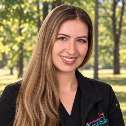 Dr. Emily, dentist at Bridge Plaza Dental in Manalapan, NJ, smiling outdoors.